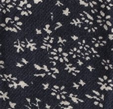 Detalle tejido corbata de lazo gris con flores blancas